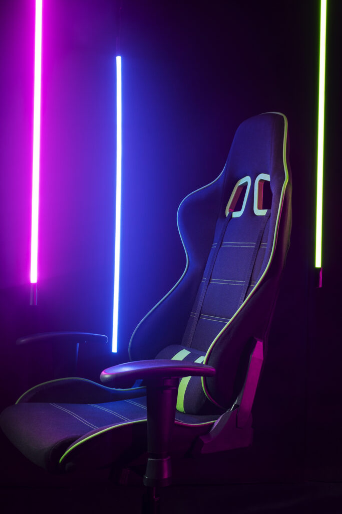 Gaming-Stuhl vor bunten Neonlichtern in einer dunklen Studio-Umgebung.